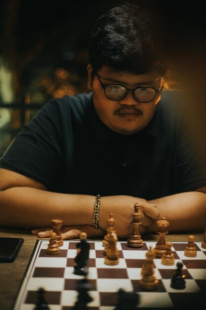 A Bangladeshi chess grandmaster in action during an international tournament, with the focus on their face showing intense concentration and strategic thinking.
