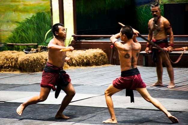 A dynamic photo of a Bangladesh karate team coach instructing a group of athletes during a training session. The coach is demonstrating a technique, while the athletes are attentively observing and practicing. The setting is a modern sports facility with training equipment visible in the background.