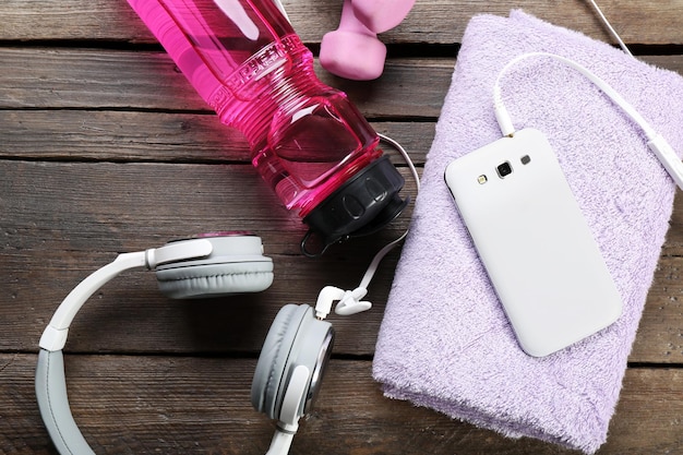 A close-up of essential items for a concert, including a phone, power bank, hand sanitizer, earplugs, and a small water bottle, neatly arranged to show preparedness.