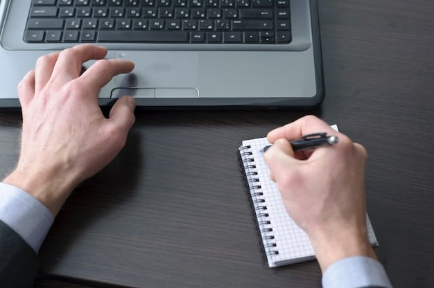 A close-up shot of a journalist's hands typing on a laptop at a press event. The journalist is focused and professional, with a notepad and pen nearby.
