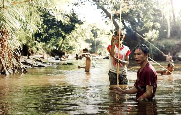A group of volunteers distributing food and water to flood-affected people in a rural area of Bangladesh, showcasing the community support during the disaster.